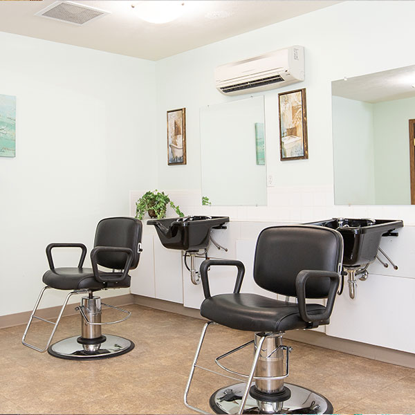 salon featuring two stylish chairs and a large mirror reflecting the space.